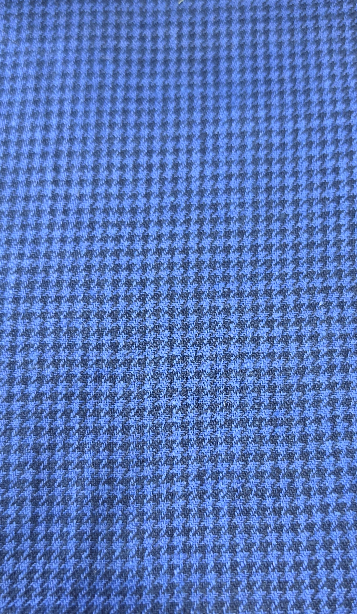 A close-up of a blue and gray houndstooth fabric pattern.