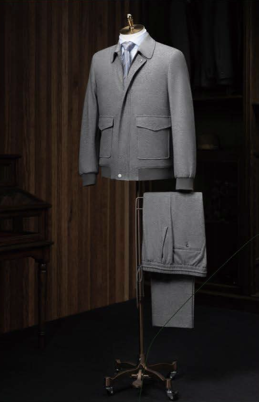 A medium grey casual jacket and plus medium grey trousers displayed on a mannequin, featuring a slim fit with single button fastening, patched flapped pockets, and grey ribbing on the hem.