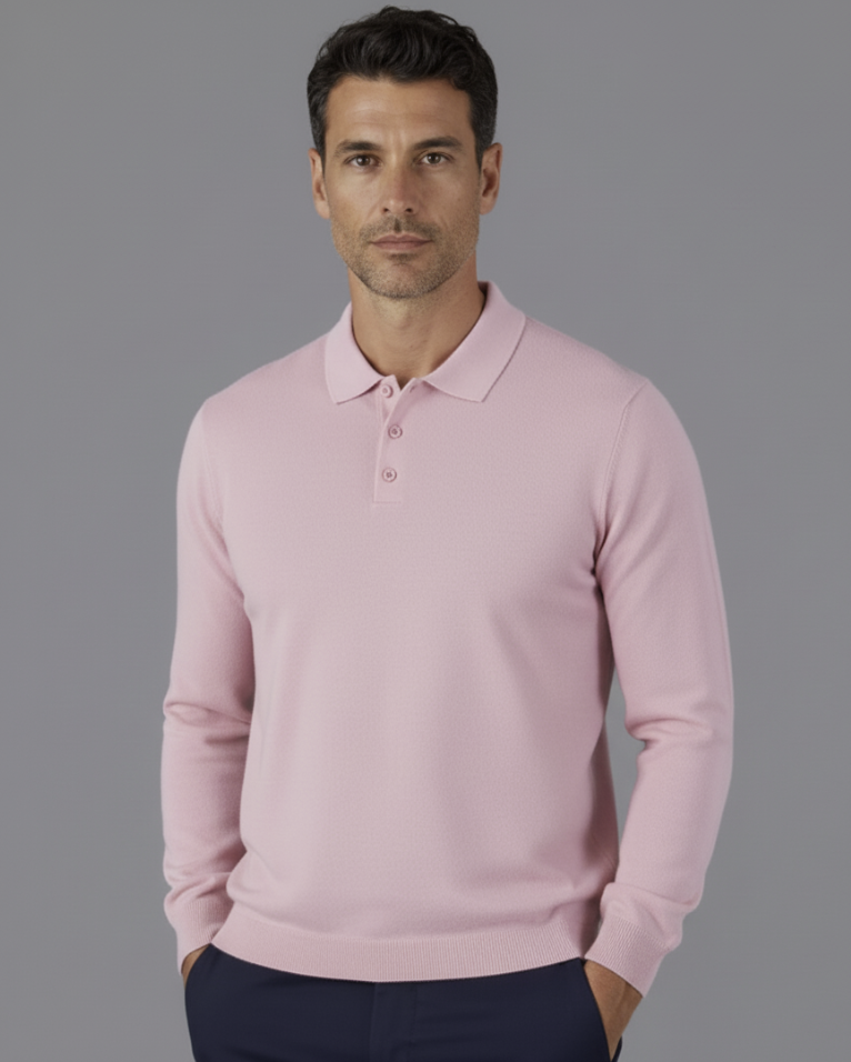 Man wearing a light pink sweater over a white shirt on a gray background