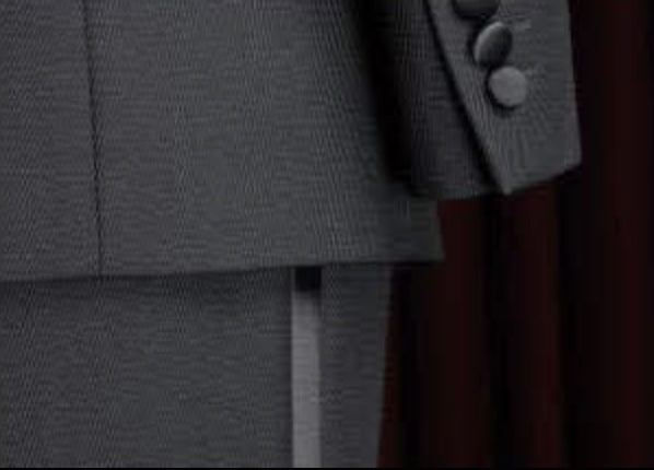 Close-up of a gray textured fabric with buttons on a dark background