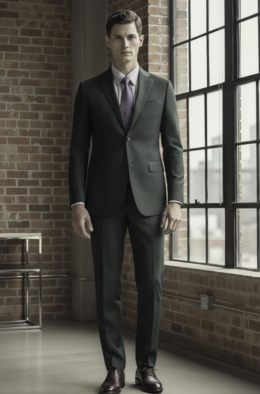 Man wearing a gray suit standing in a room with brick walls and large windows.