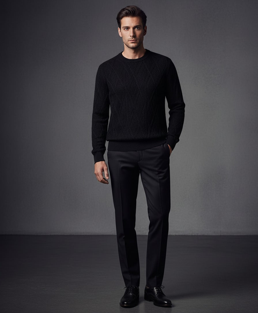 Man wearing a black sweater and pants against a gray background
