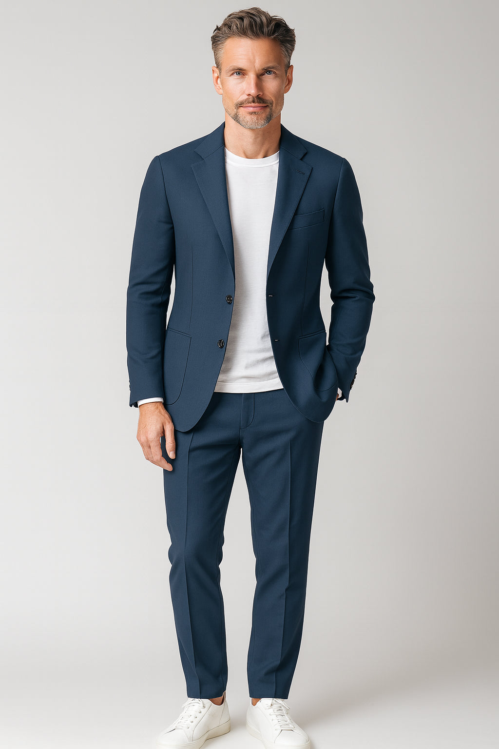 Man wearing a navy suit with a white shirt on a light gray background