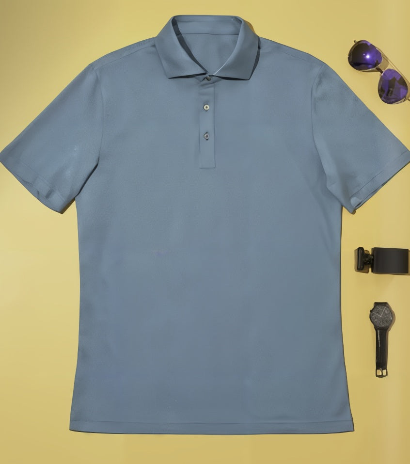 Teal polo shirt on a yellow background with sunglasses and a watch.