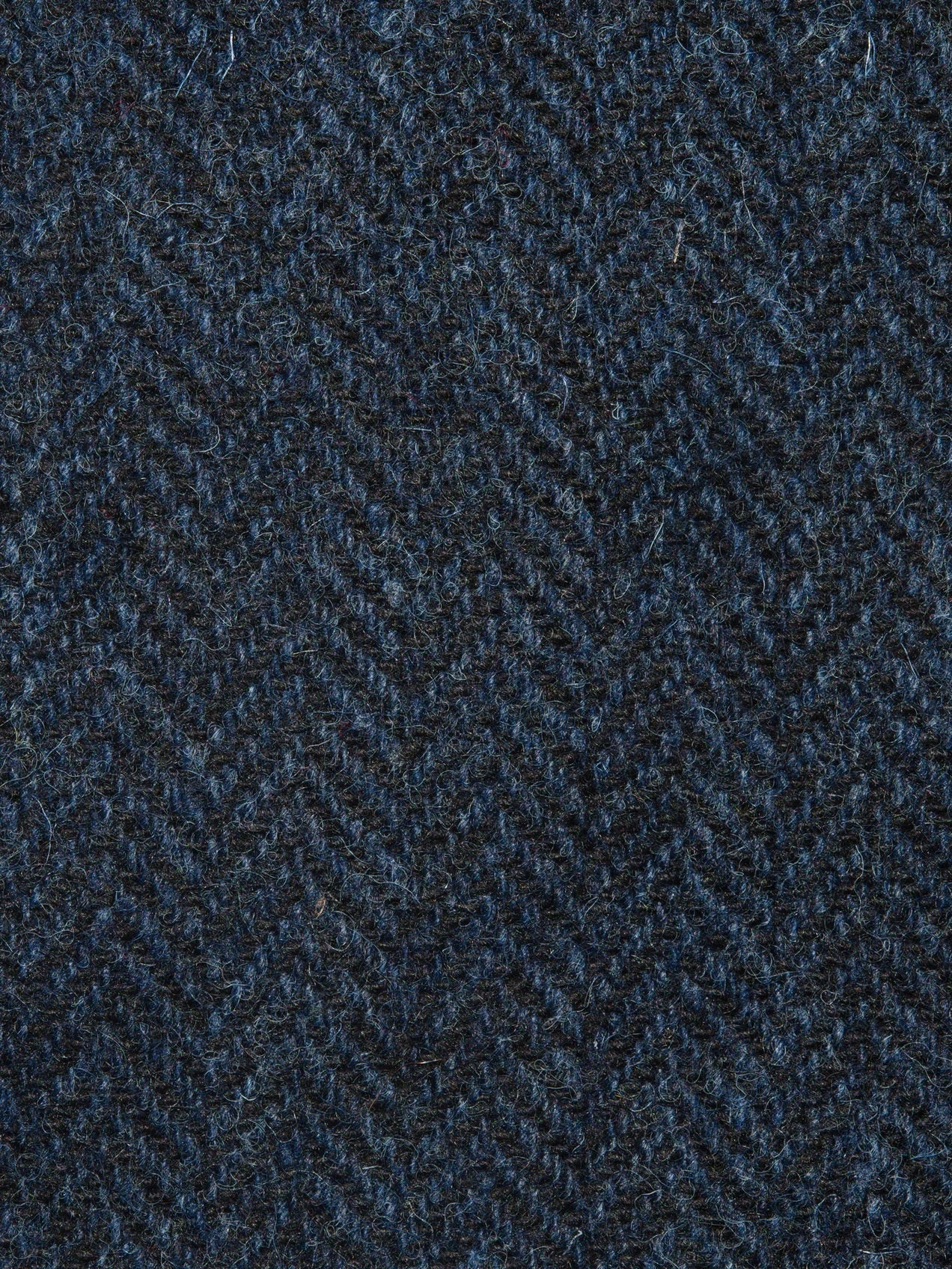 Textured fabric with a herringbone pattern in dark blue tones.