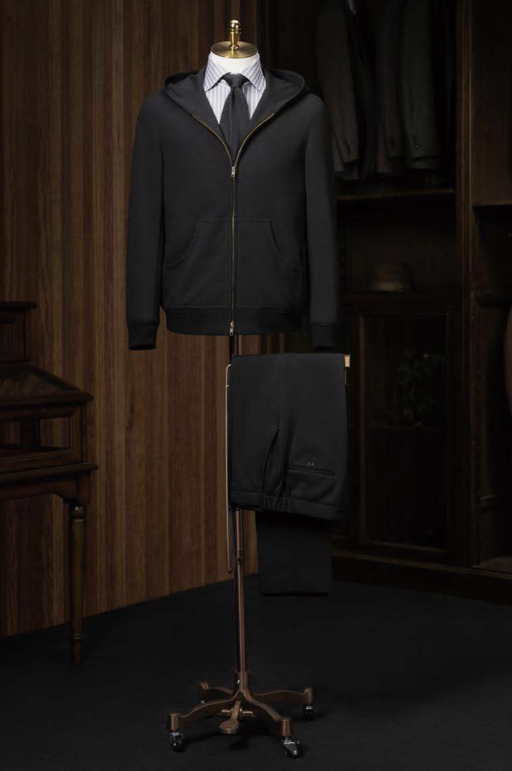 A black casual hooded zip jacket displayed on a mannequin with trousers, showcasing a slim fit and front zip detail.