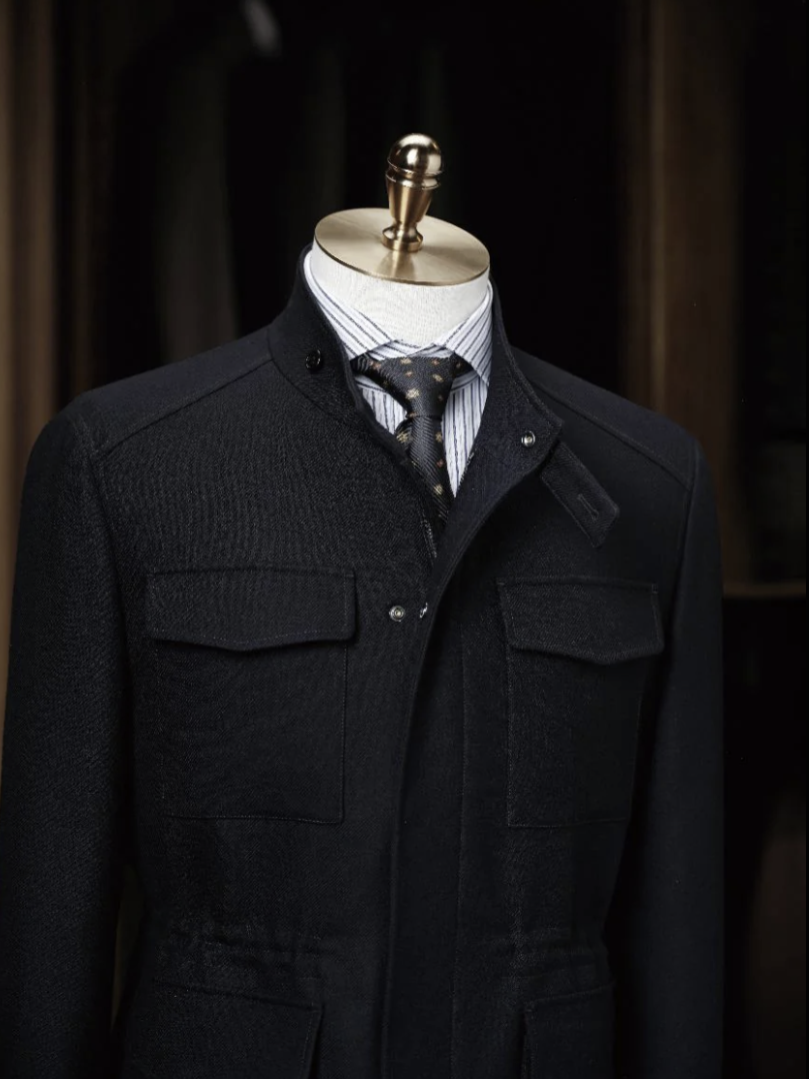 Navy coat on a mannequin with a dark background