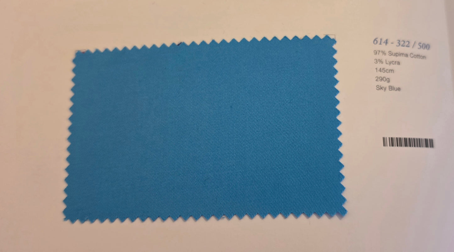 A blue fabric color swatch card with serrated edges, showing a textured sky blue material. To the right of the swatch, printed text identifies the color as 'Sky Blue' and lists other color codes and a barcode.