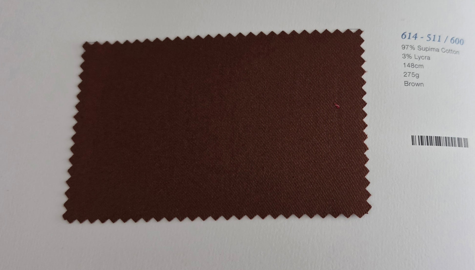 A brown fabric swatch with serrated edges displayed on a white background next to printed color information.
