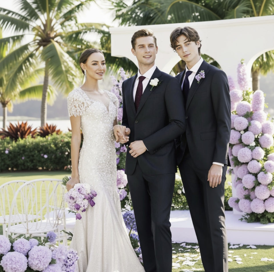 Two individuals in formal attire standing in front of a floral arch with palm trees in the background.