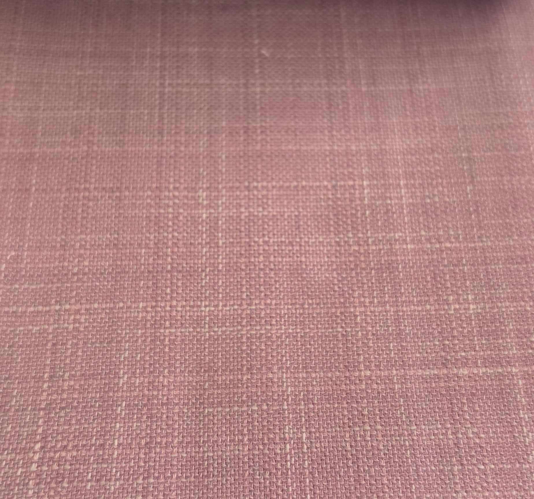 A close-up of a dusty rose pink woven fabric with a subtle grid pattern.