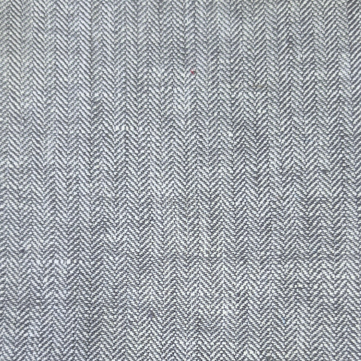 A close-up of a gray and white herringbone woven fabric texture.