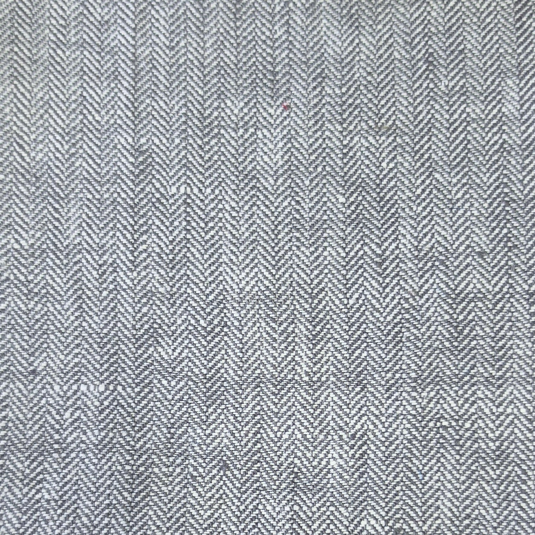 A close-up of a gray and white herringbone woven fabric texture.