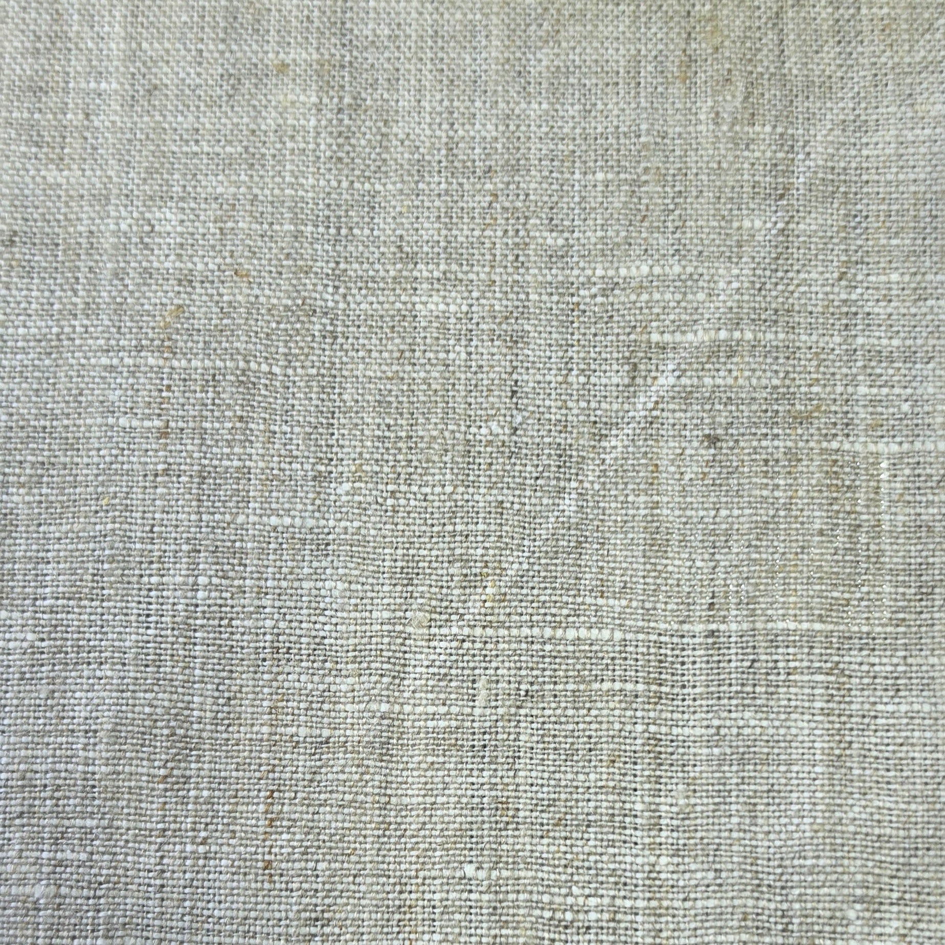A close-up of a light beige linen fabric texture with a natural woven pattern.