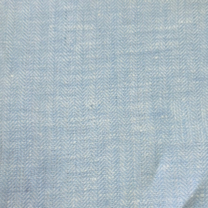 A close-up of a light blue and white herringbone patterned fabric, showing the woven texture and subtle folds.