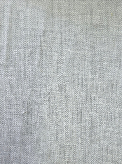 A close-up of a light gray and white herringbone woven fabric texture.