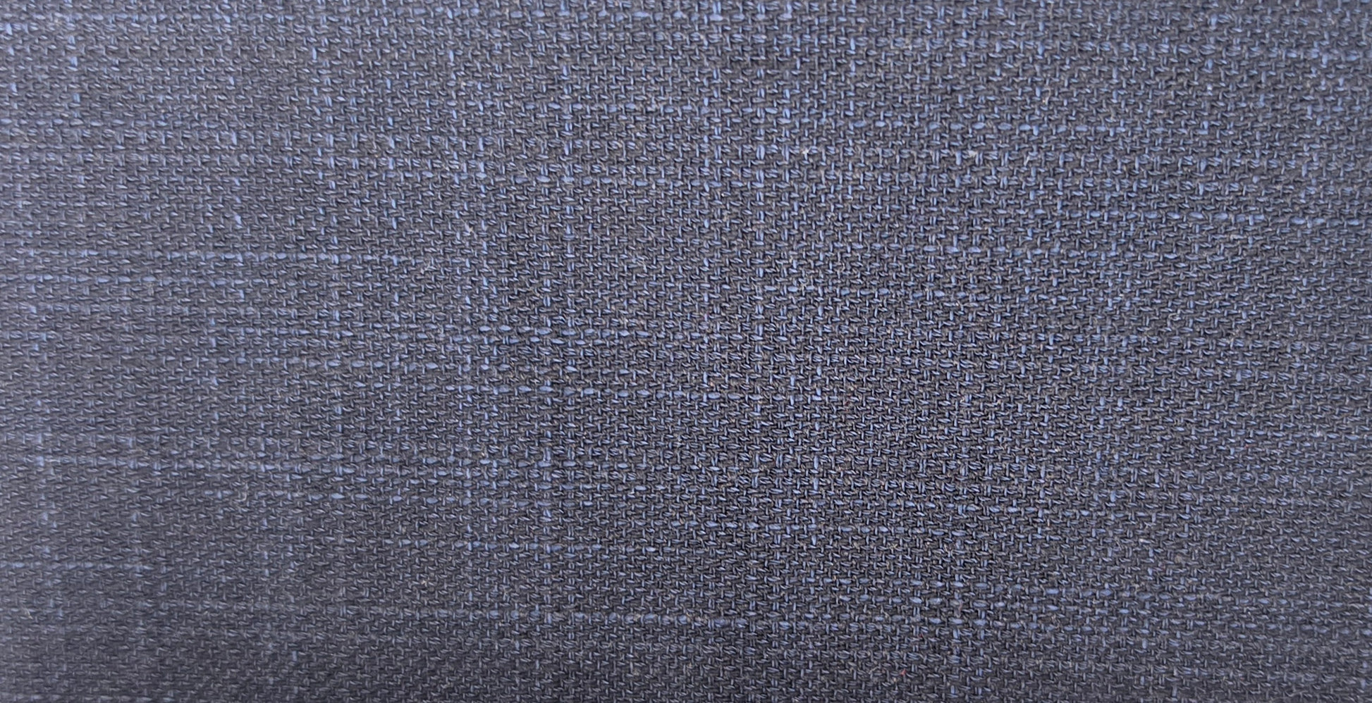 A close-up of a textured fabric with a subtle blue and gray plaid pattern.