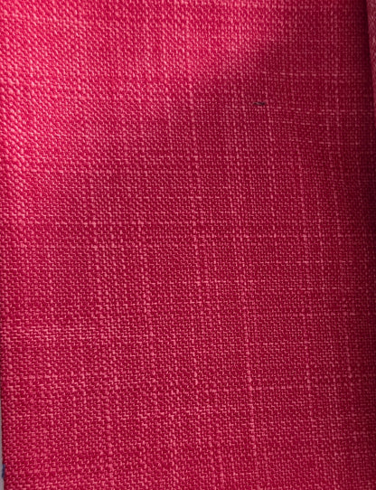 A close-up of a textured woven fabric in a rich magenta pink color, showing the detailed linen-like weave pattern.