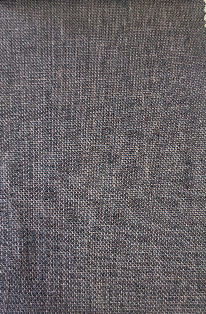 A close-up of a woven fabric swatch in a dark brown color, showing the texture and weave pattern, with a light wood surface visible at the bottom.