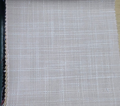 A close-up of a woven fabric swatch showing a light beige and white grid pattern, with a dark edge on the left and a tan edge on the right.