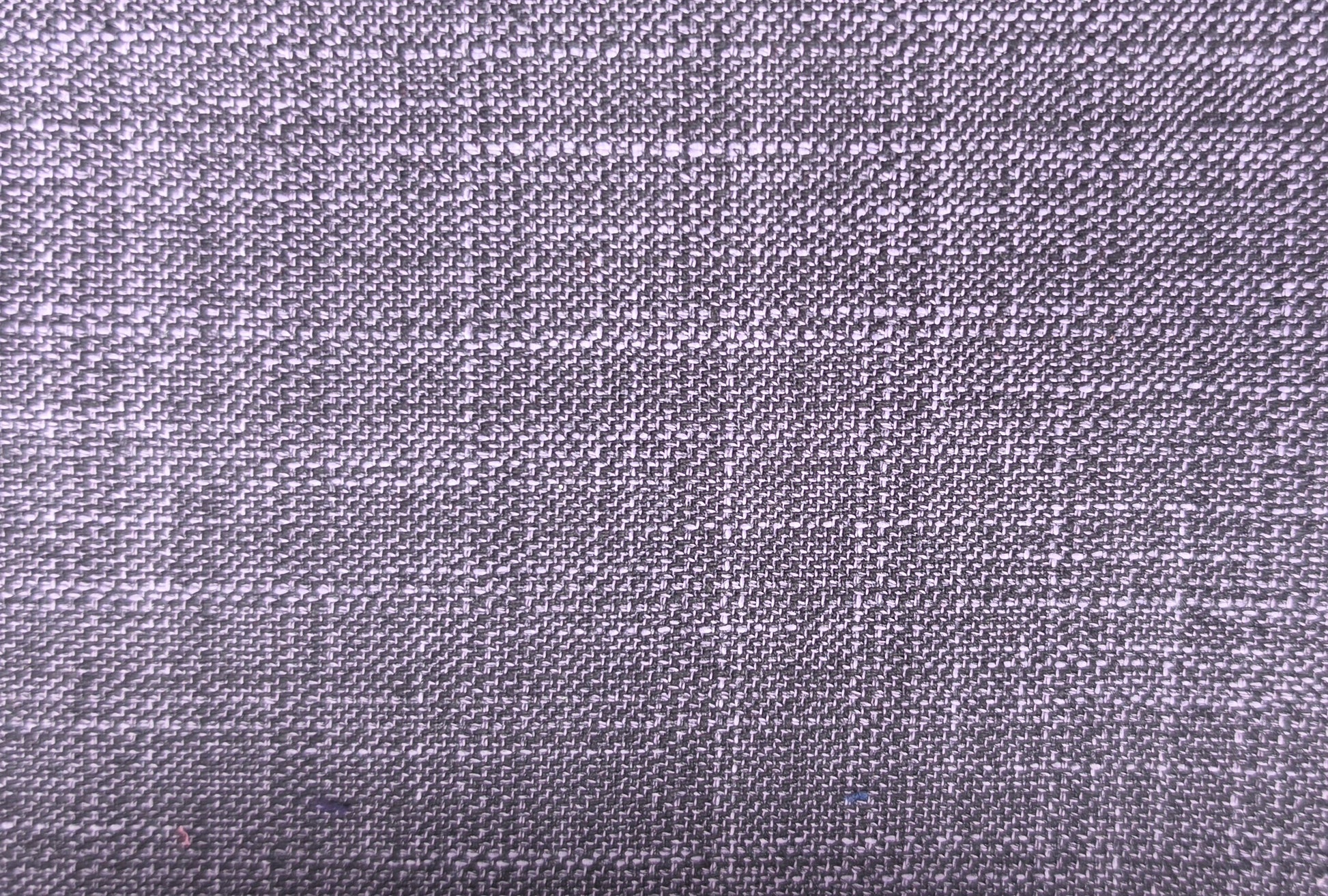 A close-up of a woven fabric texture in a muted lavender-gray color, showing the detailed weave pattern.