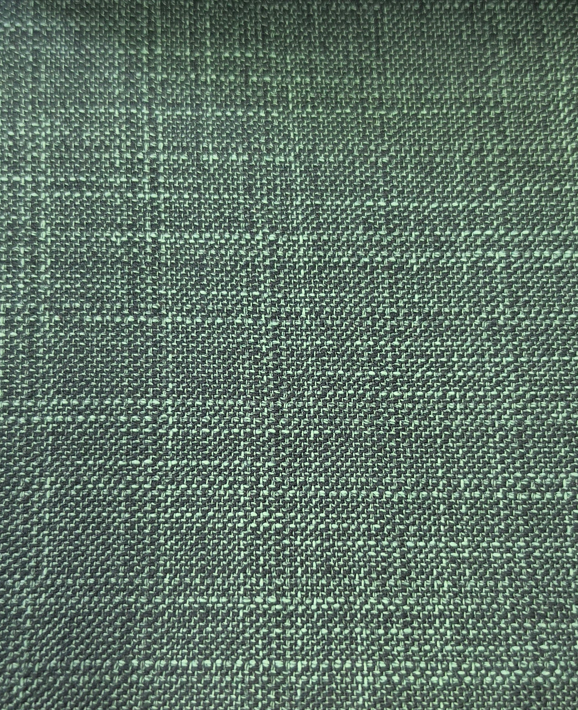A close-up of a woven fabric texture in a muted sage green color with a subtle plaid pattern.