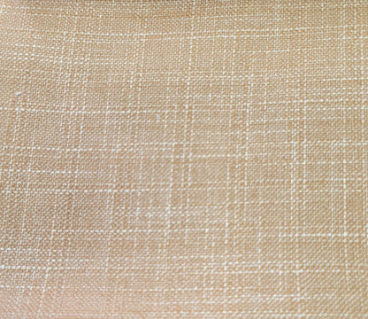 A close-up of a woven fabric texture in a warm beige color with a subtle white grid pattern.