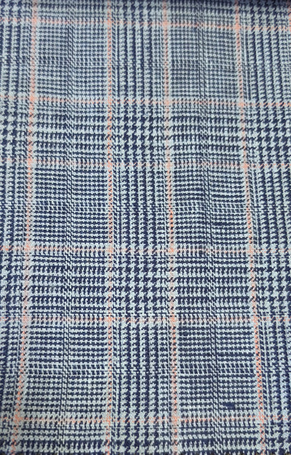 A close-up of a woven fabric with a blue and white houndstooth pattern overlaid with a light pink plaid grid.