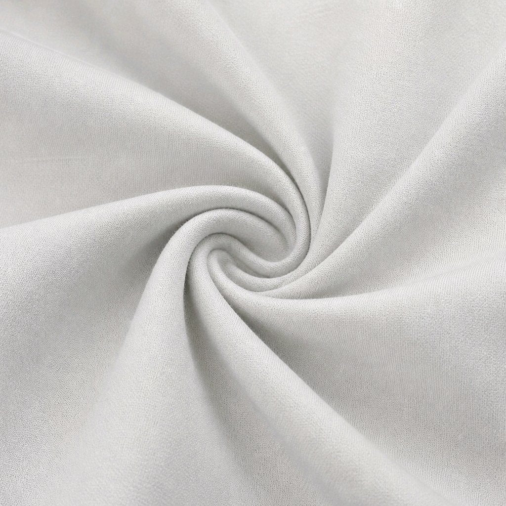 A close-up of light Ivory fabric arranged in a spiral swirl, showing the material texture and drape.