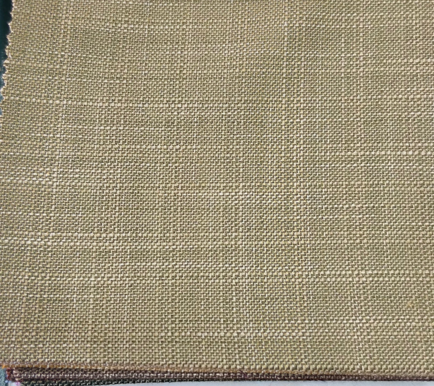 A close-up of woven fabric with a subtle windowpane plaid pattern in beige and tan tones.