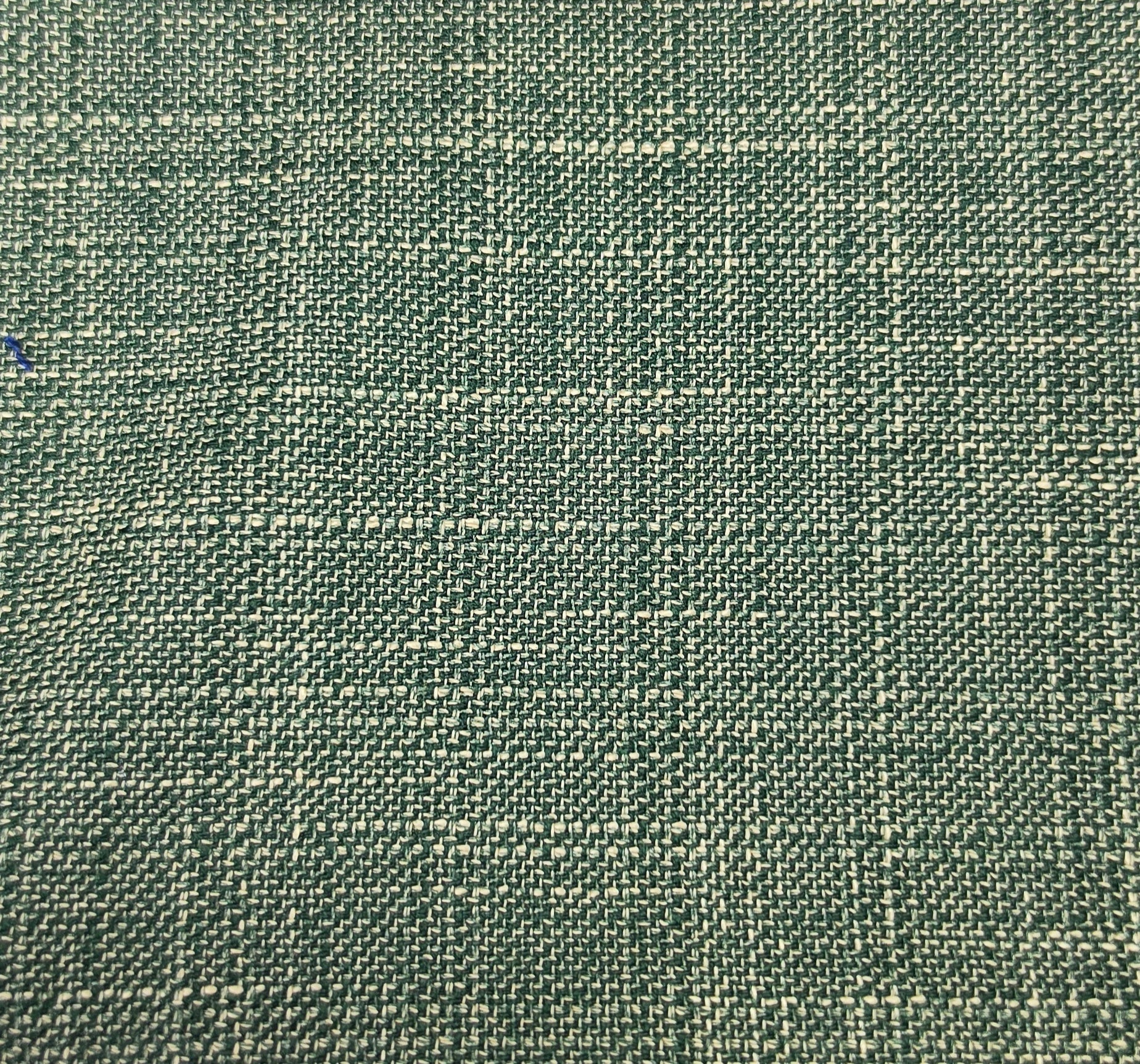 A close-up of woven fabric with a textured, basketweave-like pattern in muted green and beige tones.