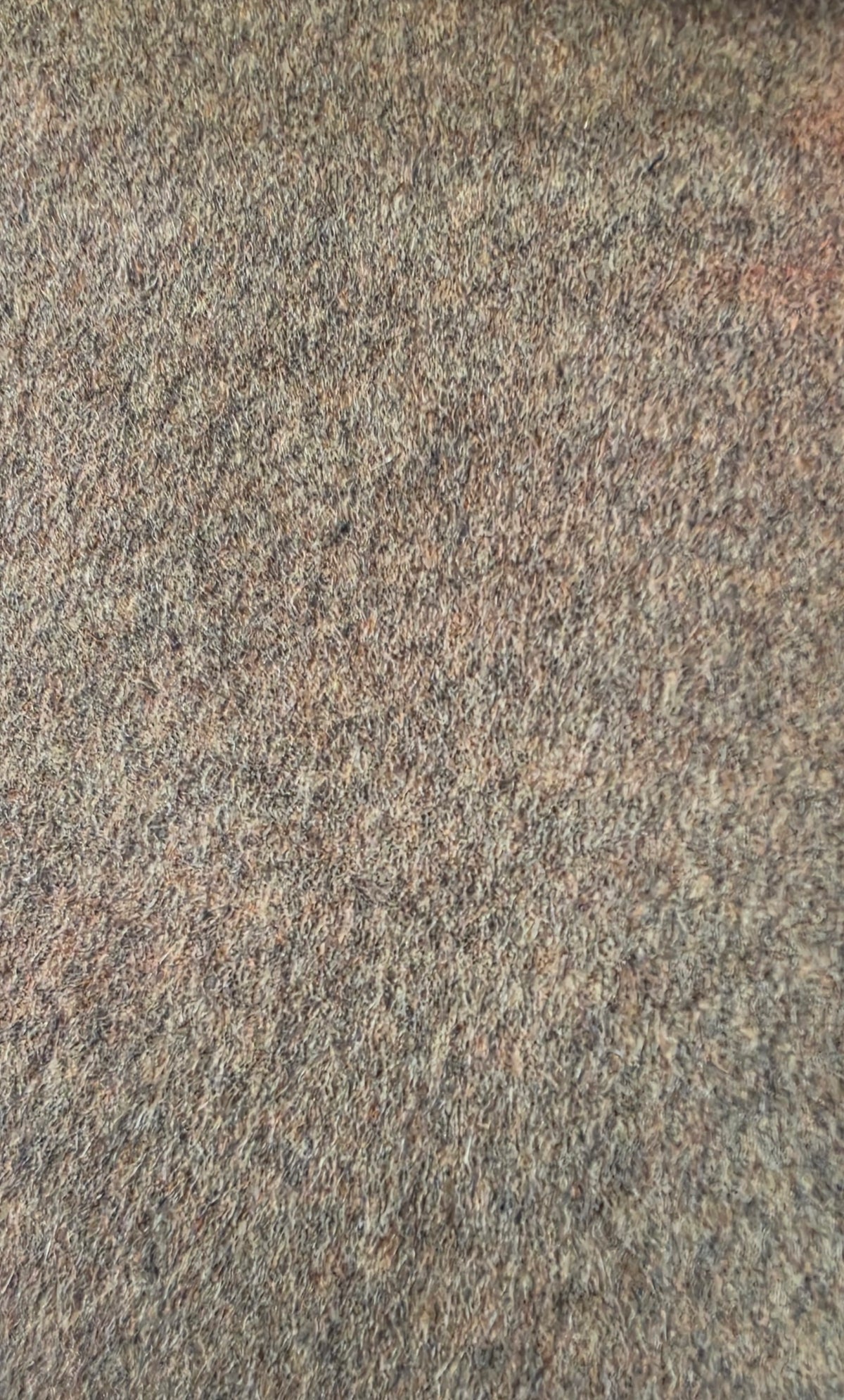 A close-up texture shot of a mottled wool fabric with a blend of gray, brown, and beige fibers.