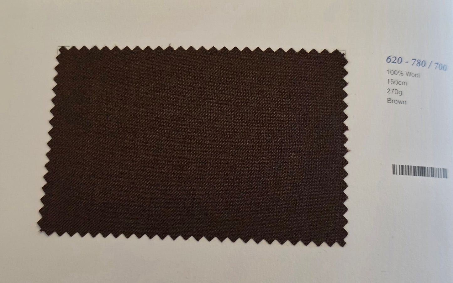 A dark brown fabric swatch with serrated edges displayed on a white background next to printed color and material details.