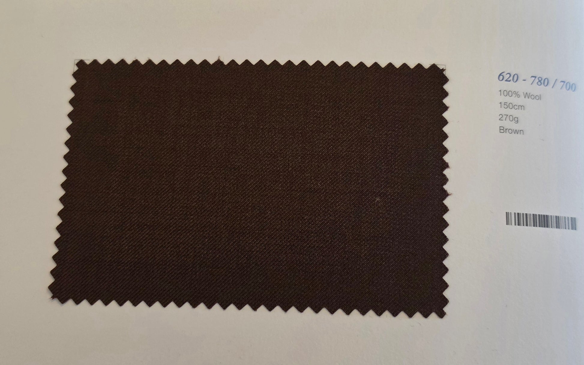 A dark brown fabric swatch with serrated edges displayed on a white background next to printed color and material details.