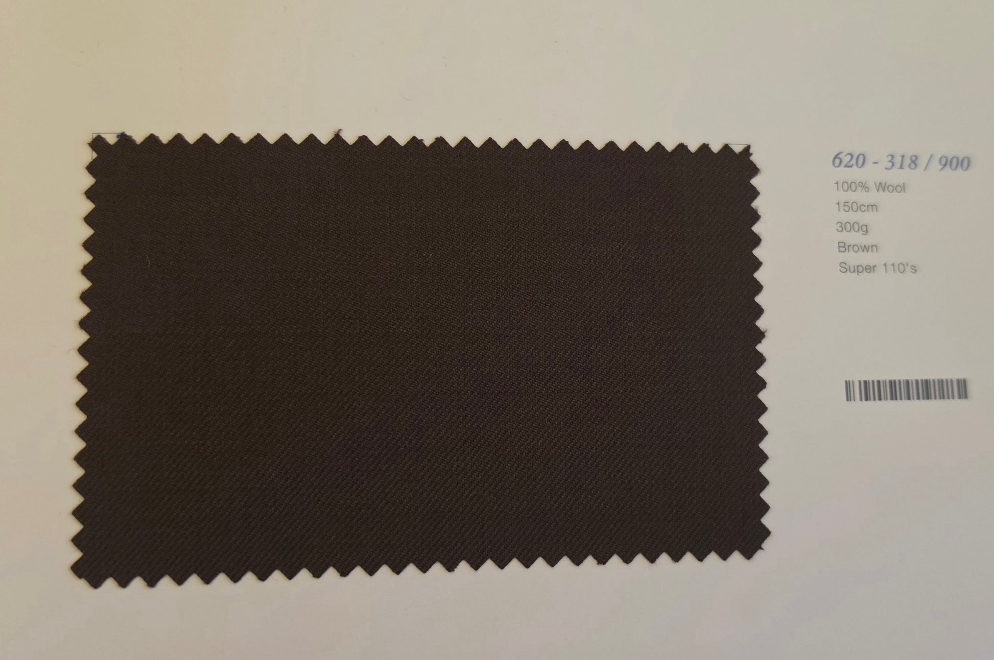 A dark brown fabric swatch with zigzag-cut edges, displayed on a light background next to printed color and specification text.