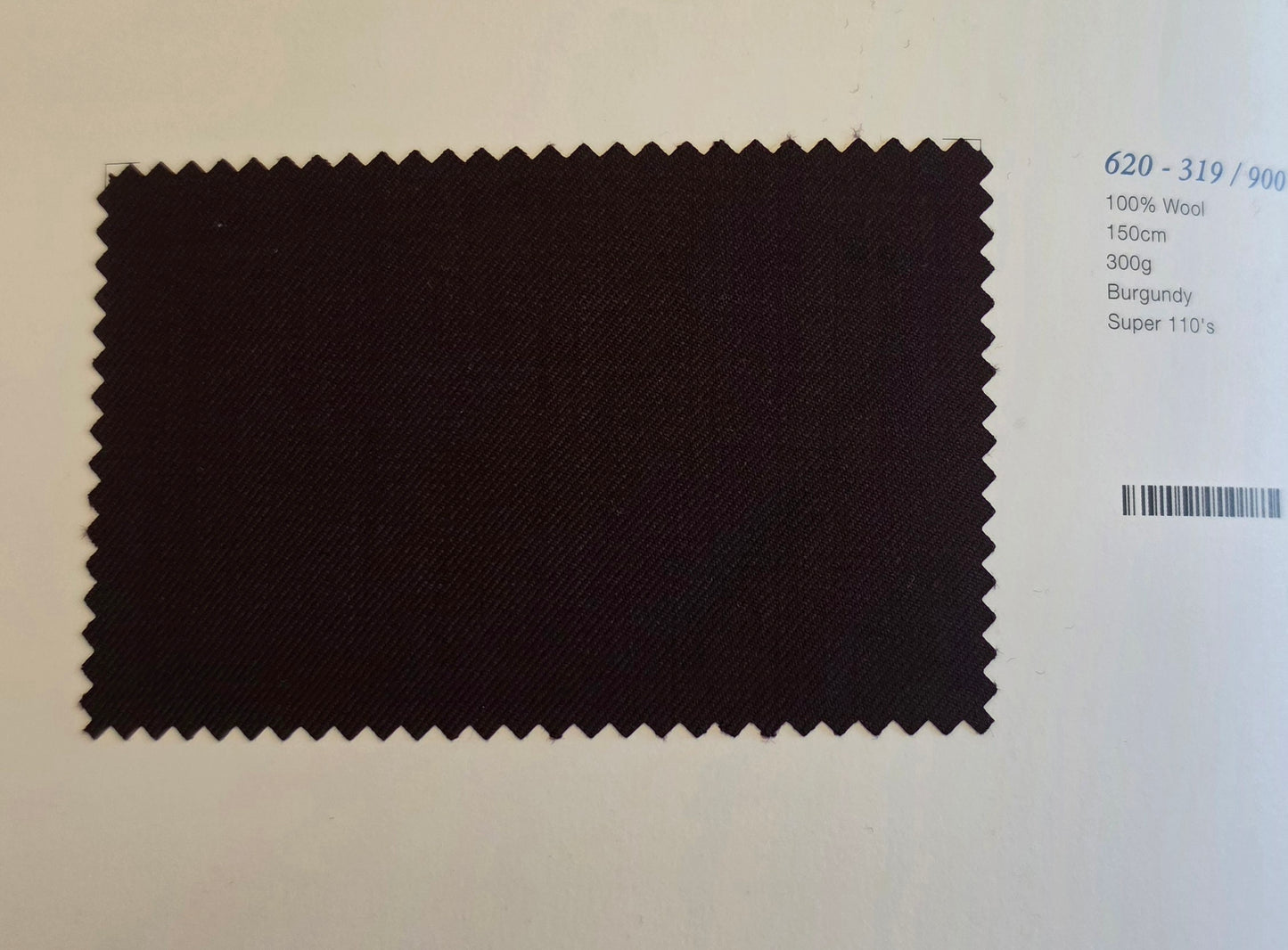 A dark burgundy wool fabric swatch with serrated edges, displayed on a white background next to printed specifications.