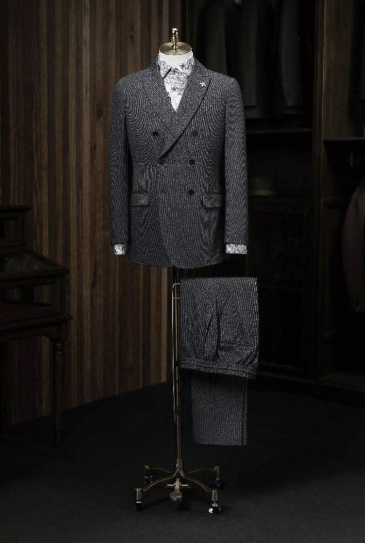 A dark grey textured double-breasted casual jacket displayed on a mannequin with matching trousers, featuring a slim fit, double vents, and front pockets.