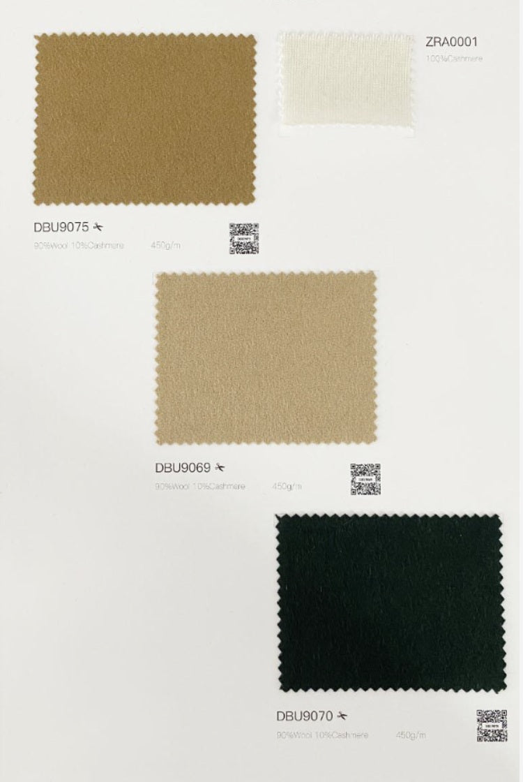 A fabric color swatch card showing three textured material samples with printed codes: a medium tan square labeled DBJ90075, a small off-white square labeled ZRA0001, and a dark charcoal-black square labeled DBJ90070, on a white background.