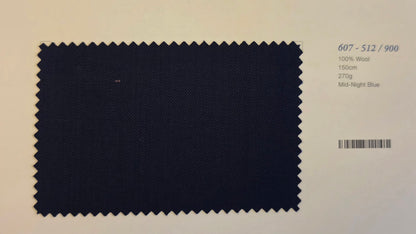 A fabric color swatch of Mid-Night Blue wool, showing a dark navy blue textured weave with zigzag-cut edges, displayed on a light beige background with product details printed on the right.