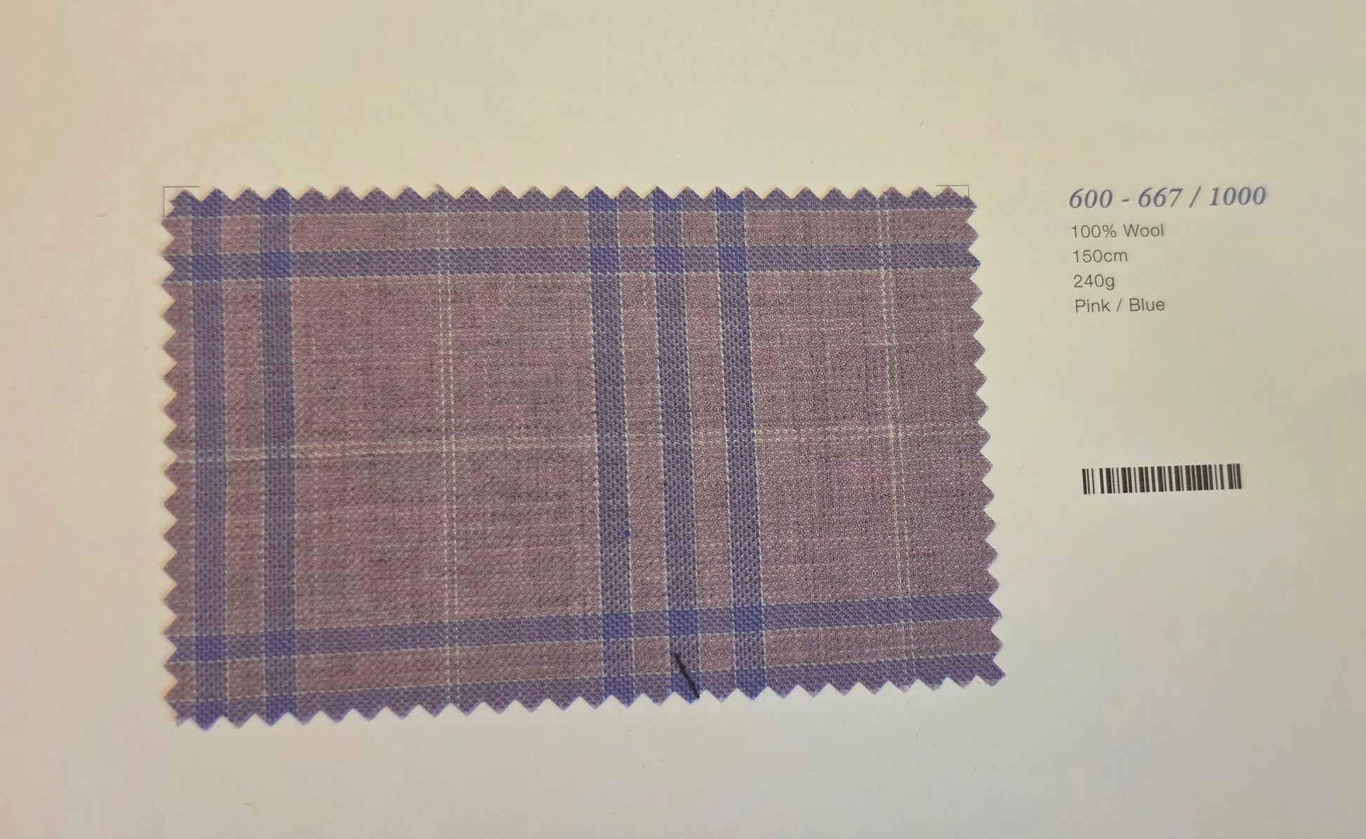 A fabric swatch card showing a purple and blue plaid pattern on a light background, with printed text on the right indicating wool composition and color details.