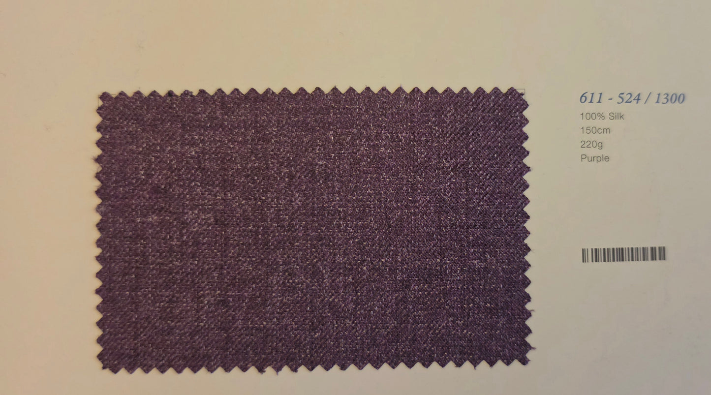 A fabric swatch card showing a textured purple silk material sample with zigzag-cut edges, alongside printed text including the code '611 - S24 / 1300' and '100% Silk 150m 220g Purple'.