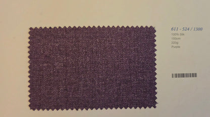 A fabric swatch card showing a textured purple silk material sample with zigzag-cut edges, alongside printed text including the code '611 - S24 / 1300' and '100% Silk 150m 220g Purple'.