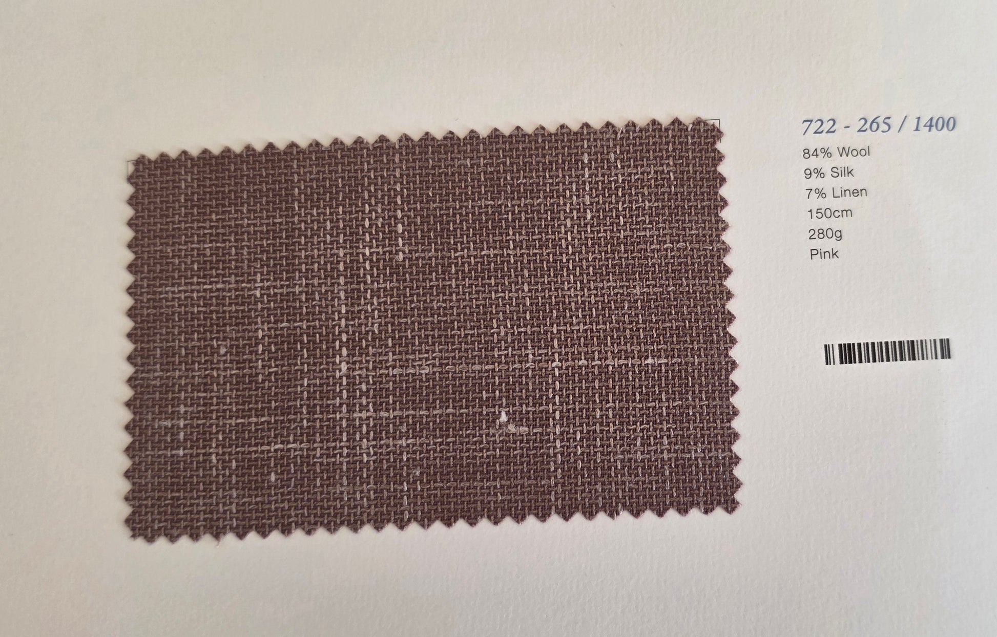 A fabric swatch card showing a textured woven material in a dusty mauve-pink color, with printed details on the right side including a barcode and composition text.