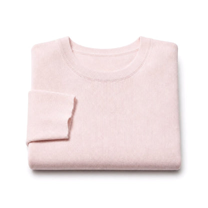 A folded light pink ribbed knit sweater on a clean white background.