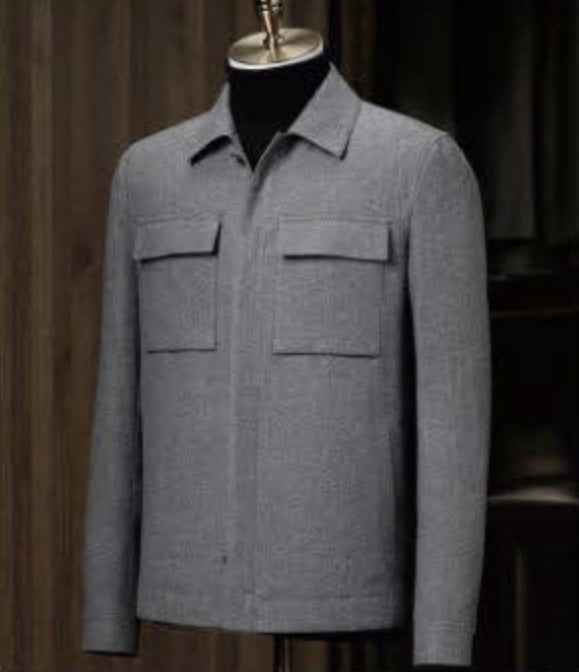 A grey casual jacket displayed on a mannequin, featuring a high shirt collar, patched chest pockets, and a front with grey buttons.