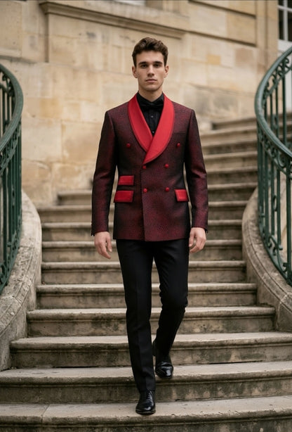 A man walks down a stone staircase wearing a double-breasted blazer in a deep burgundy red with vibrant red shawl lapels and pocket flaps, paired with black trousers and a black shirt.