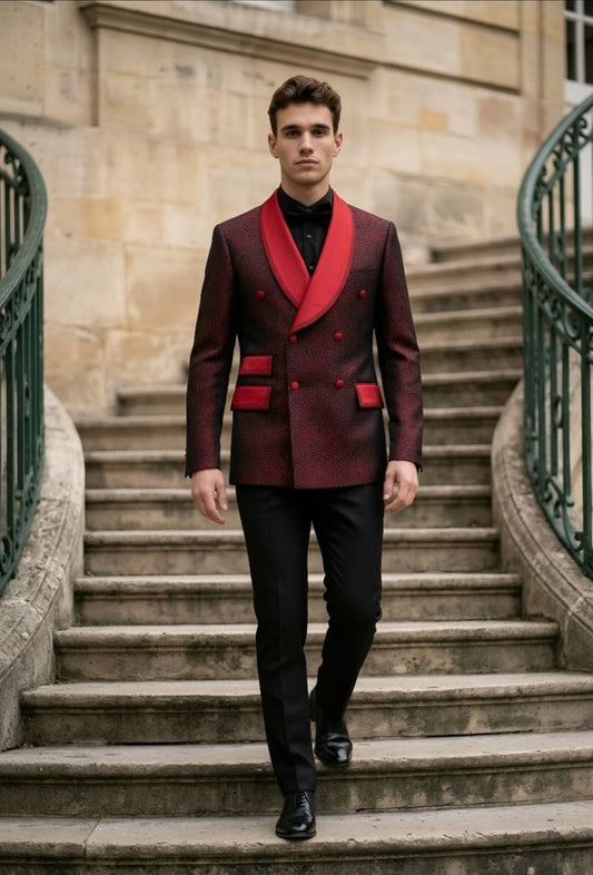 A man walks down a stone staircase wearing a double-breasted blazer in a deep burgundy red with vibrant red shawl lapels and pocket flaps, paired with black trousers and a black shirt.