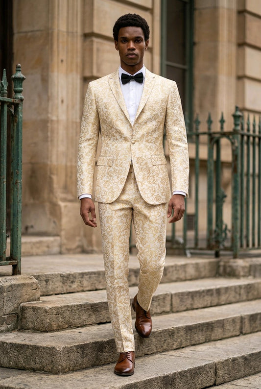 A man wearing a beige patterned suit with a white shirt, black bow tie, and brown dress shoes, walking down stone steps in front of a stone building.
