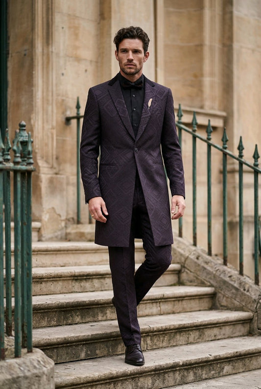 A man wearing a dark black textured overcoat, matching trousers, and a black shirt walks down stone stairs with green railings.