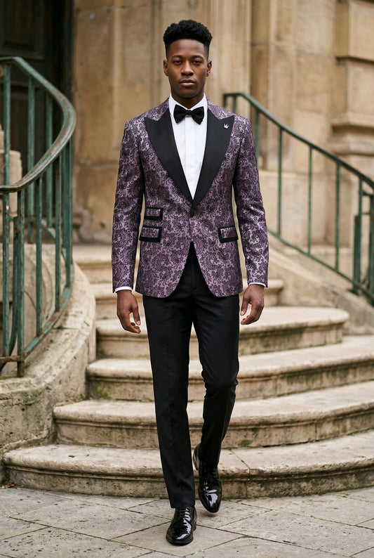 A man wearing a grey and black patterned tuxedo jacket with black peak lapels, a white shirt, and a black bow tie walks down stone steps.